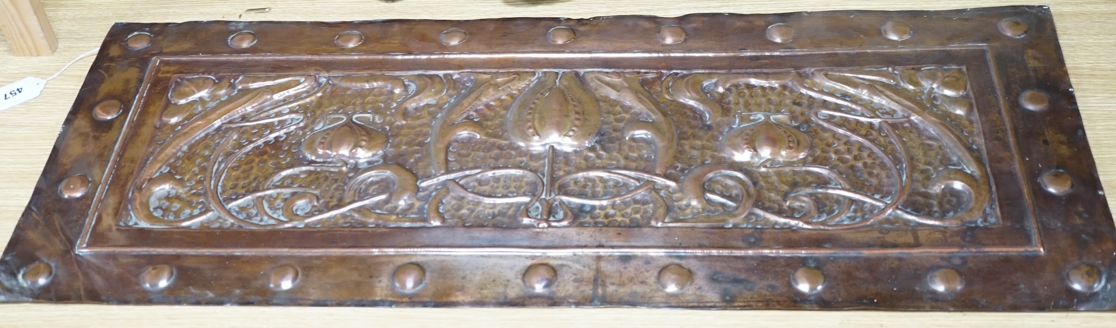 An Art Nouveau copper panel, embossed with stylised flowers and roundels, 39 x 99cm. Condition - fair